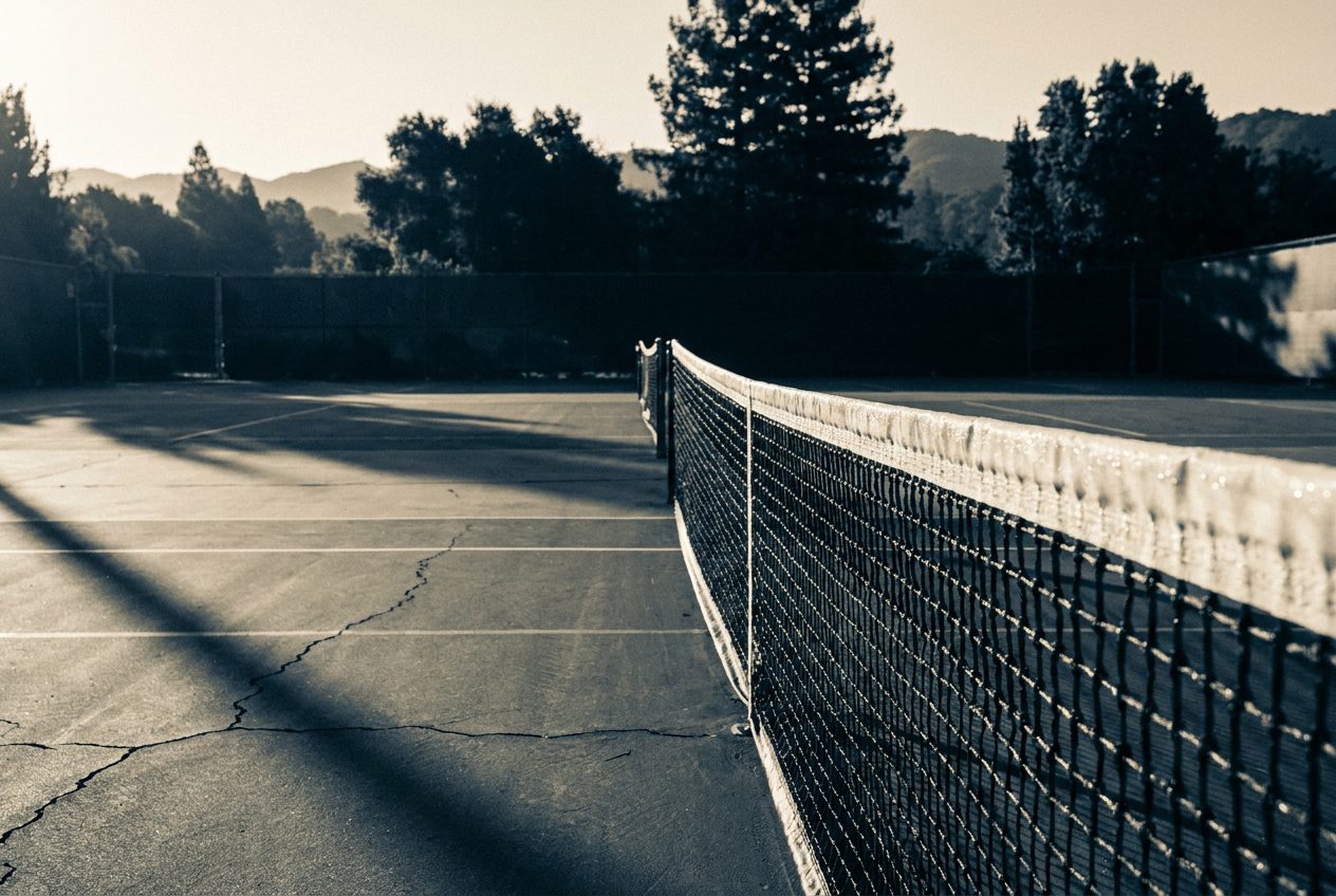 An empty tennis court in early morning light